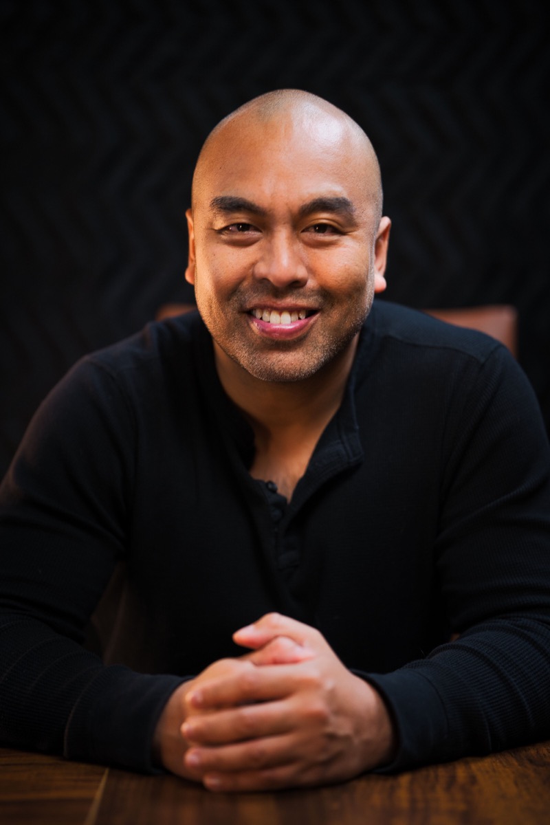 Jet Bunditwong seated at a table, smiling